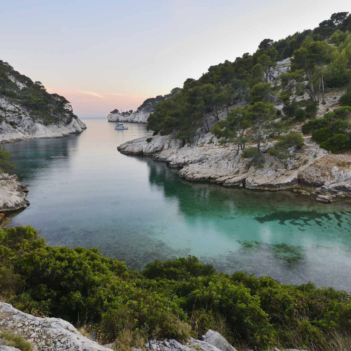 Peaceful twilight view over the calm waters and forested cliffs of Port-Pin.