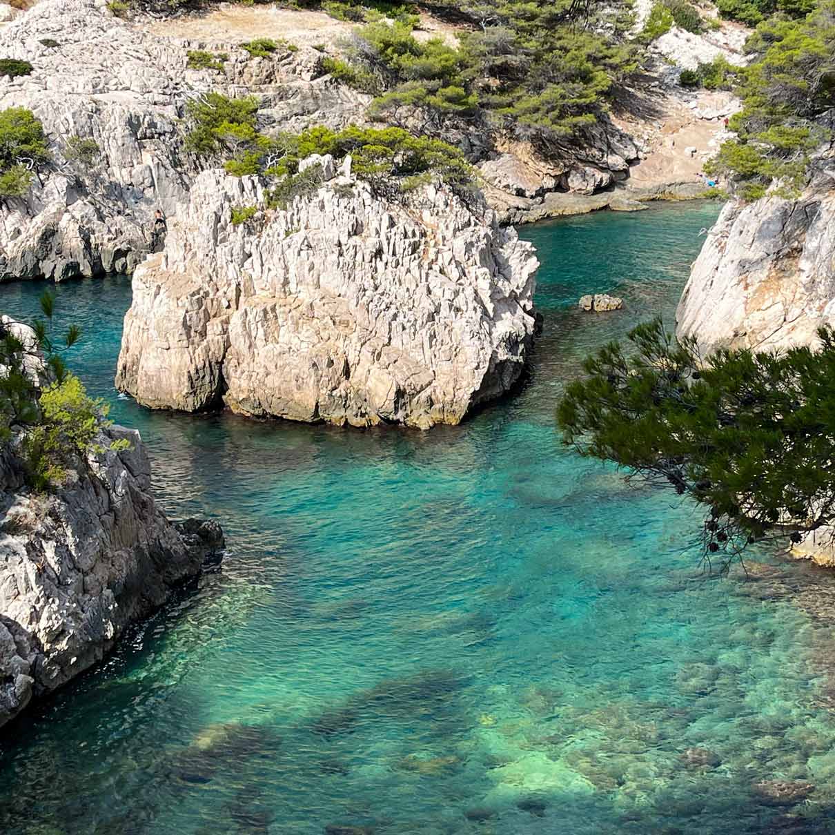 Close-up of the rocky Sugiton islet surrounded by translucent water.