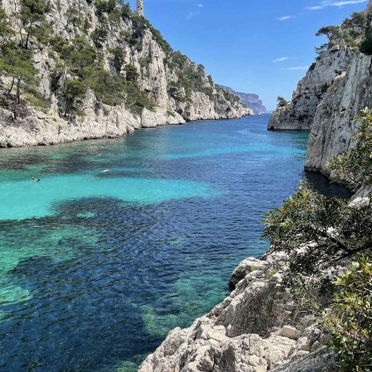 Natural rock arch standing in the blue waters of the Marseille coastline.