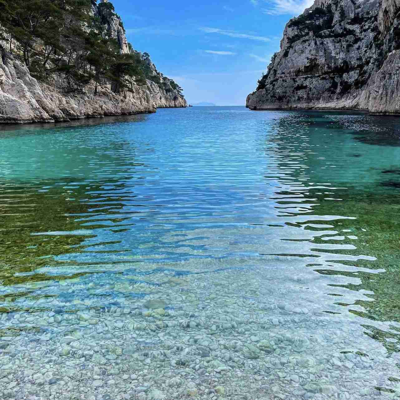 High white limestone cliffs towering over the turquoise waters of En-Vau.
